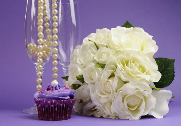 Wedding bouquet of white roses with purple cupcake and pearls in champagne glass — Stock Photo, Image