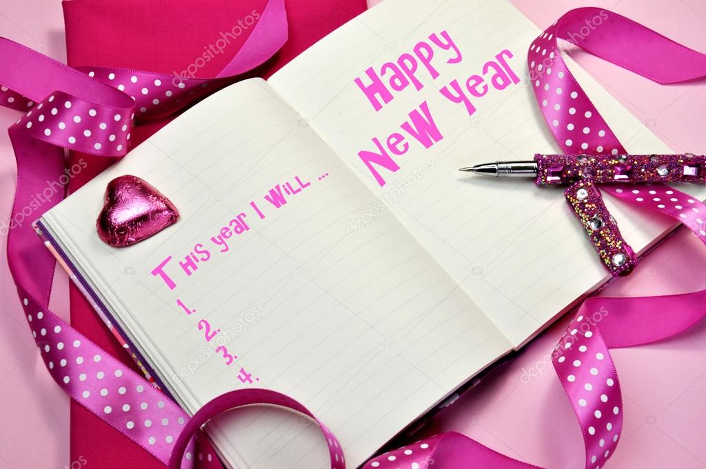Happy New Year resolutions in diary journal book with pretty feminine pink ribbons