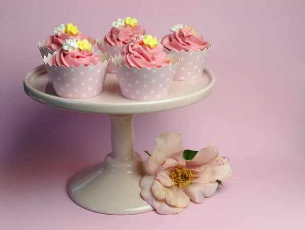 Beautiful pink decorated cupcakes on pink cake stand for birthday, wedding or female special event occasion.