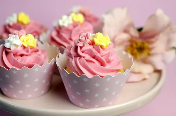 Vacker rosa dekorerade cupcakes på rosa tårta står för födelsedag, bröllop eller kvinna speciell händelse tillfälle. närbild med bokeh. — Stockfoto