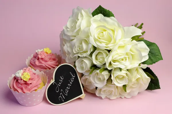 Wedding white roses bouquet with pink cupcake, with Just Married message on heart shape blackboard. — Stock Photo, Image