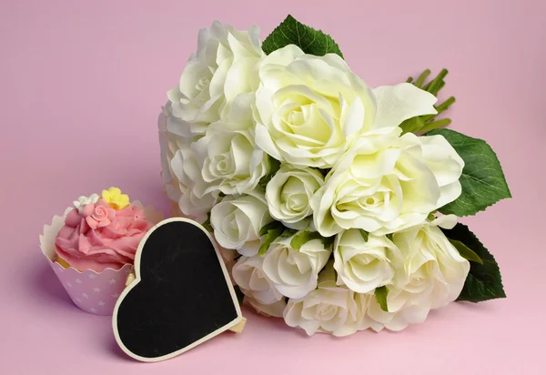 Ramo de rosas blancas de boda con cupcake rosa con pizarra en forma de corazón con espacio de copia para su texto aquí . —  Fotos de Stock