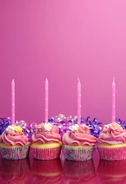 Розовые праздничные кексы со свечами в горошек на розовом фоне. Вертикаль с местом для копирования . — стоковое фото