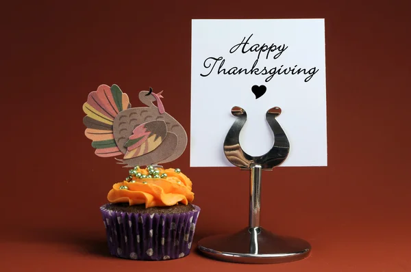 Feliz mensaje de Acción de Gracias en el soporte de la mesa con cupcake naranja con decoración de pavo . — Foto de Stock