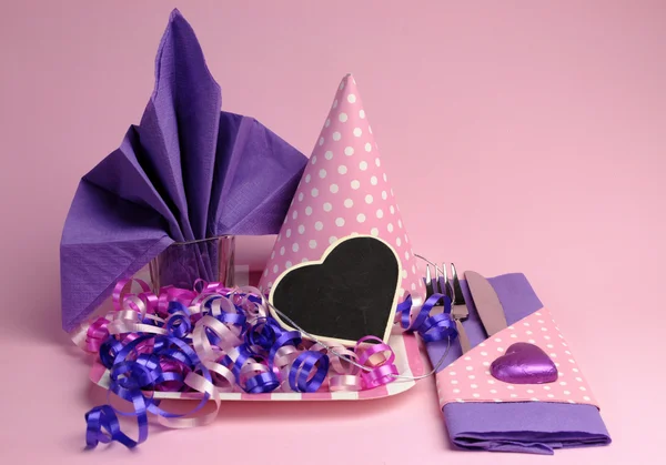 Decorações de configuração de mesa de festa de tema rosa e roxo, contra um fundo rosa pálido .. — Fotografia de Stock