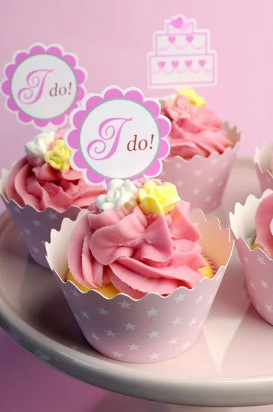 Roze bruiloft cupcakes met ik doen topper tekenen - close-up met bokeh verticale. Stockfoto