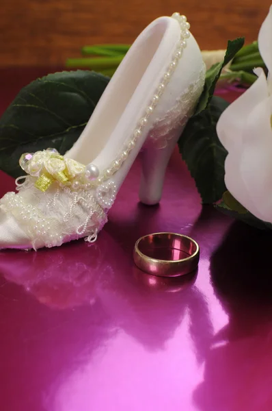 婚礼新娘花束白玫瑰粉红色背景与运气好鞋和结婚戒指上。垂直与副本空间. — 图库照片