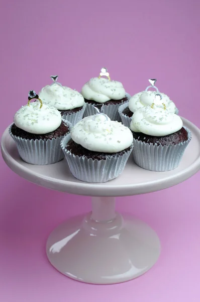 Matrimonio tema cioccolato rosso valvet cupcakes su stand rosa con anelli di diamanti decorazioni nuziali — Foto Stock