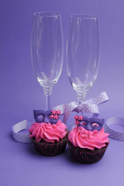 Pink and purple masquerade masks decorated party cupcakes with pink frosting — Stock Photo, Image