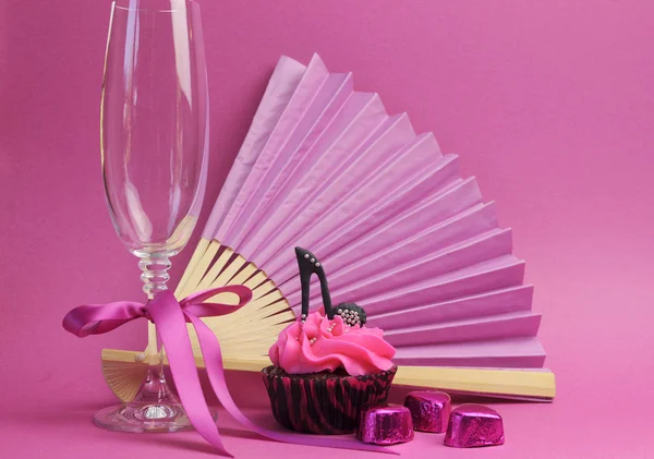 Roze partij cupcake met zwarte stilleto hoge hak schoen met champagne glas, ventilator en chocolade — Stockfoto