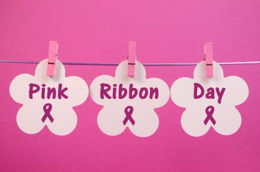 pembe mandal bir çizgi üzerinde asılı beyaz çiçekler arasında yazılı pembe kurdele gün mesaj tebrik