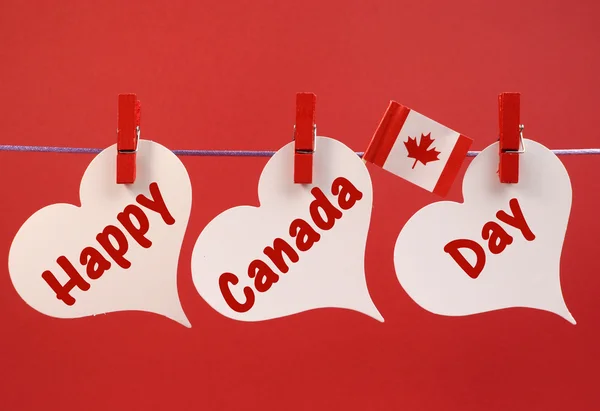 Ευτυχής ημέρα Καναδά χαιρετισμό μήνυμα με το καναδικό σφεντάμι φύλλο σημαία που κρέμεται από μανταλάκια μιας γραμμής — Φωτογραφία Αρχείου