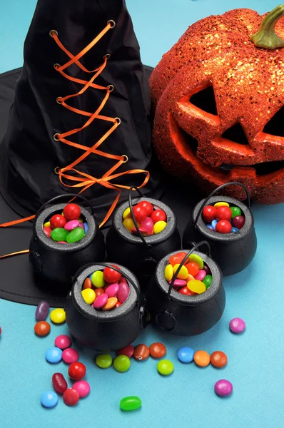 Halloween witch hat and cauldrons full of candy — Stock Photo, Image