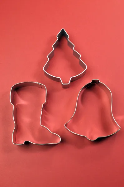 Χριστούγεννα cookie cutter σχήματα σε κόκκινο φόντο — Φωτογραφία Αρχείου