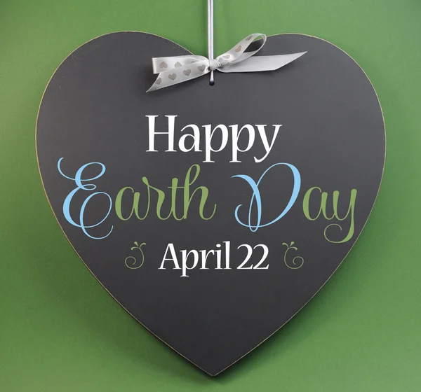 Happy Earth Day April 22, message sign greeting on a heart shaped blackboard against a green background. — Stock Photo, Image