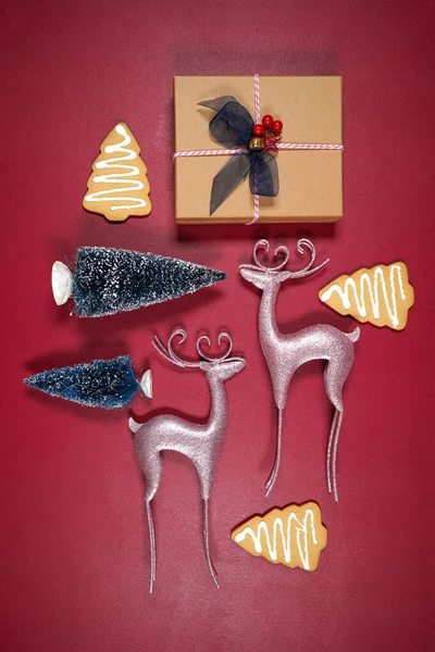 Christmas background flatlay with pink reindeers, gift, cookies and trees. — Stock Photo, Image