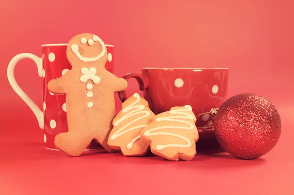 Gingerbread man with red polka dot coffee mug and tea cup with C — Stock Photo, Image