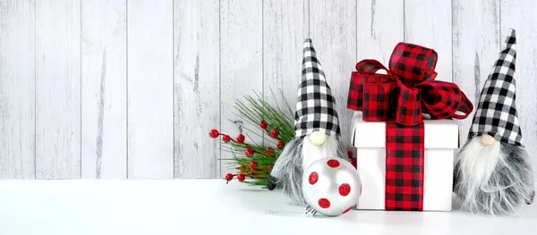 Fondo de estilo granja de Navidad con regalo de lazo a cuadros rojos y gnomos. — Foto de Stock