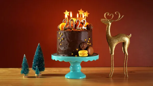 Happy New Years Eve 2022 chocolate cake decorated with gold burning candles — Stock Photo, Image