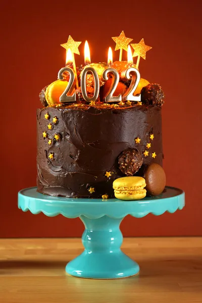 Szczęśliwego Nowego Roku 2022 ciasto czekoladowe ozdobione złotem płonące świece — Zdjęcie stockowe