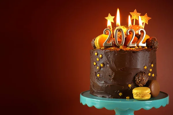 Happy New Years Eve 2022 chocolate cake decorated with gold burning candles — Stock Photo, Image