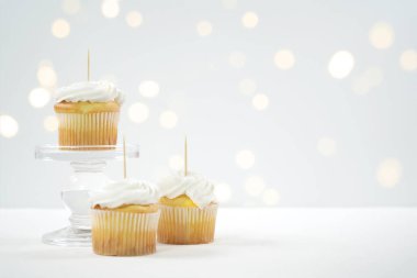 Cupcake Topper Mockup. Bokeh parti peri ışıklarıyla beyaz arkaplan.