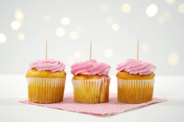 Cupcake Topper Mockup. Bokeh parti peri ışıklarıyla beyaz arkaplan.