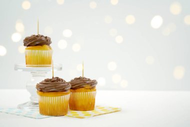 Cupcake Topper Mockup. Bokeh parti peri ışıklarıyla beyaz arkaplan.