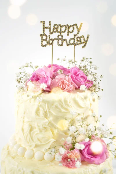 Gâteau à 2 niveaux de mariage ou d'anniversaire avec lumières de fête Bokeh. Photo De Stock