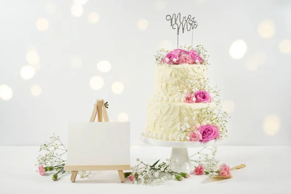 Gâteau à 2 niveaux de mariage ou d'anniversaire avec lumières de fête Bokeh. Photos De Stock Libres De Droits