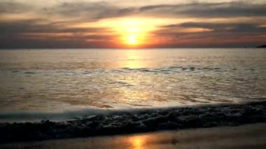The light from the sun is about to go down. Reflected light hits the sea surface.