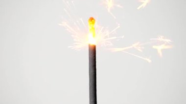 Close up, Sparks of fireworks on sticks. And the light of the fireworks gradually goes out. On the white background.