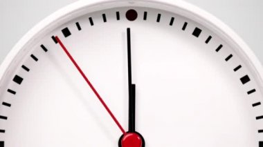 Time lapse, White watch with a short hand and a long hand pointing to the number twelve. The movement of the hands of the clock passed quickly. On the two tone background.