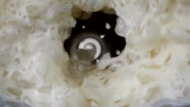Top view, The ingredients of the drink are in the blender. The blender is mixing it into a drink.