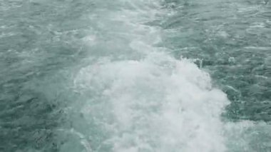 Gemi denizin yüzeyinde yelken açtıktan sonra dalgalar oluştu. Sıcak ve güneşli bir günde deniz sakin ve berrak.