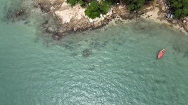 Rüzgar hafifçe esti ve tekne denizin yüzeyine demirledi. Mavi deniz suyu ve güneş ışığı su yüzeyinde parlıyor..