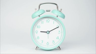 Zaman aşımına uğramış mavi alarm saati saat 10: 00 'u gösteriyor. Beyaz arka planda zaman bir günde yavaş yavaş geçti..