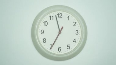Beyaz duvar saati sabah 7 'ye 2 dakika var diyor. Zaman bir günde yavaş yavaş geçti. beyaz arkaplan.