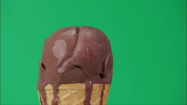 随着时间的流逝 巧克力冰淇淋在圆锥上融化了 冰淇淋水在绿色背景下缓缓流下 — 图库视频影像