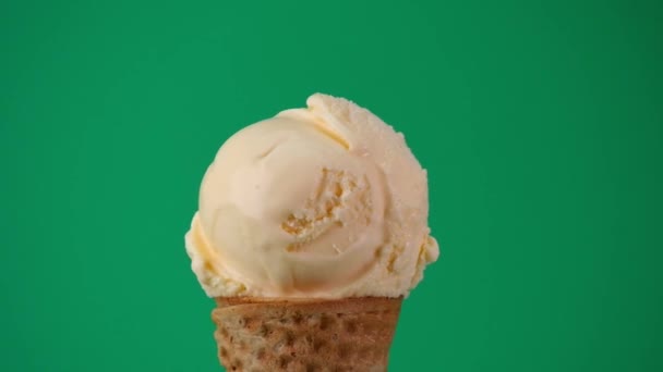 ワッフルコーンにバニラアイス コーン上の柔らかいアイスクリームの質感が回転しています 緑の背景で — ストック動画