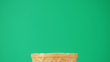 Külahta kaşıkla çikolatalı dondurma. Dondurmanın yeşil zemin üzerindeki buz ve soğuk dokusu.