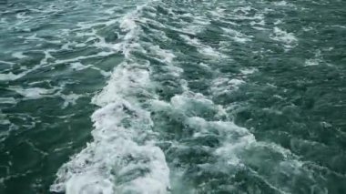 Sürat teknesi denize açıldıktan sonra su yüzeyinde dalgalar oluşur. Denizin ortasında giden bir tekne..