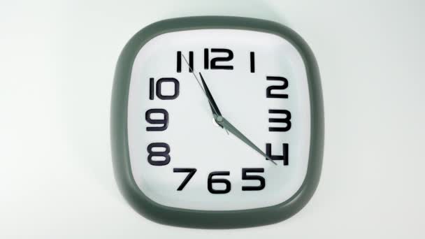 白い壁の時計は１１時に時刻を告げる 白地の上でゆっくりと時が流れ — ストック動画