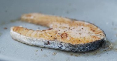 Yakın plan somon biftekleri tavada kızartılır. Somon balığının şekli ve rengi sıcakta turuncu renktedir. Yiyecek konsepti.