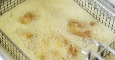 Yağ kızartma makinesinde kaynıyor. Yağ kabarcıkları kızarırken kaynıyor..