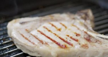 Tavada yakın plan domuz bifteği. Biftek ve tavadaki desen sıcak sobanın üzerinde. Yiyecek konsepti.