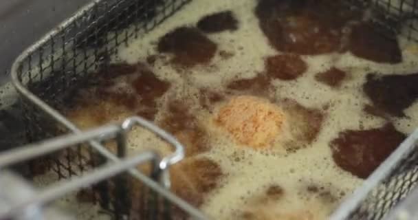 トップビューのチーズボールは沸騰した油で揚げられている 油は電気冷凍機の上で沸騰しています — ストック動画