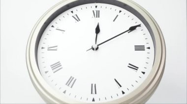 Zaman aşımlı gümüş duvar saati saat 1 yönünde. Roma rakamlarında zamanın nasıl geçtiğini gösteriyor. Beyaz arkaplanda.