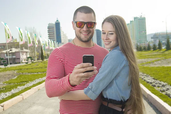 Homem e mulher felizes usando smartphone — Fotografia de Stock