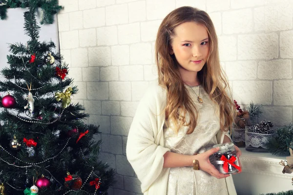 ギフト クリスマスの木の近くで赤いドレスの若い女の子 — ストック写真